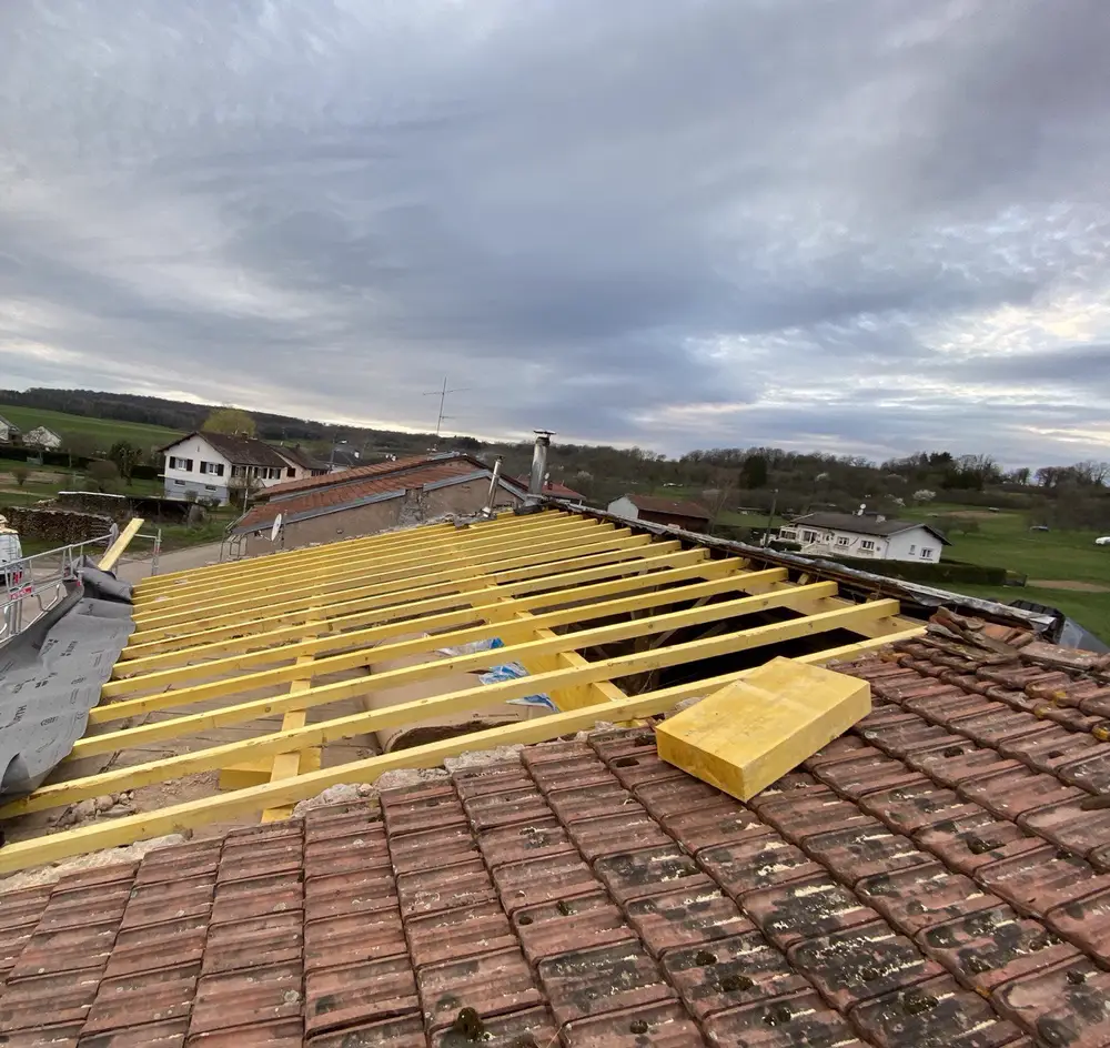 Chevrons neufs posés au-dessus d'une charpente ancienne conservée