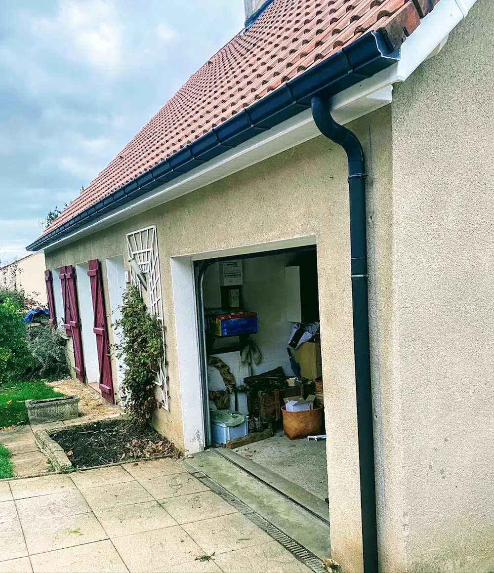 Gouttière en zinc et descente posées le long d'une façade de cour