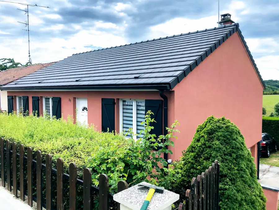Maison à façade claire couverte en tuile anthracite