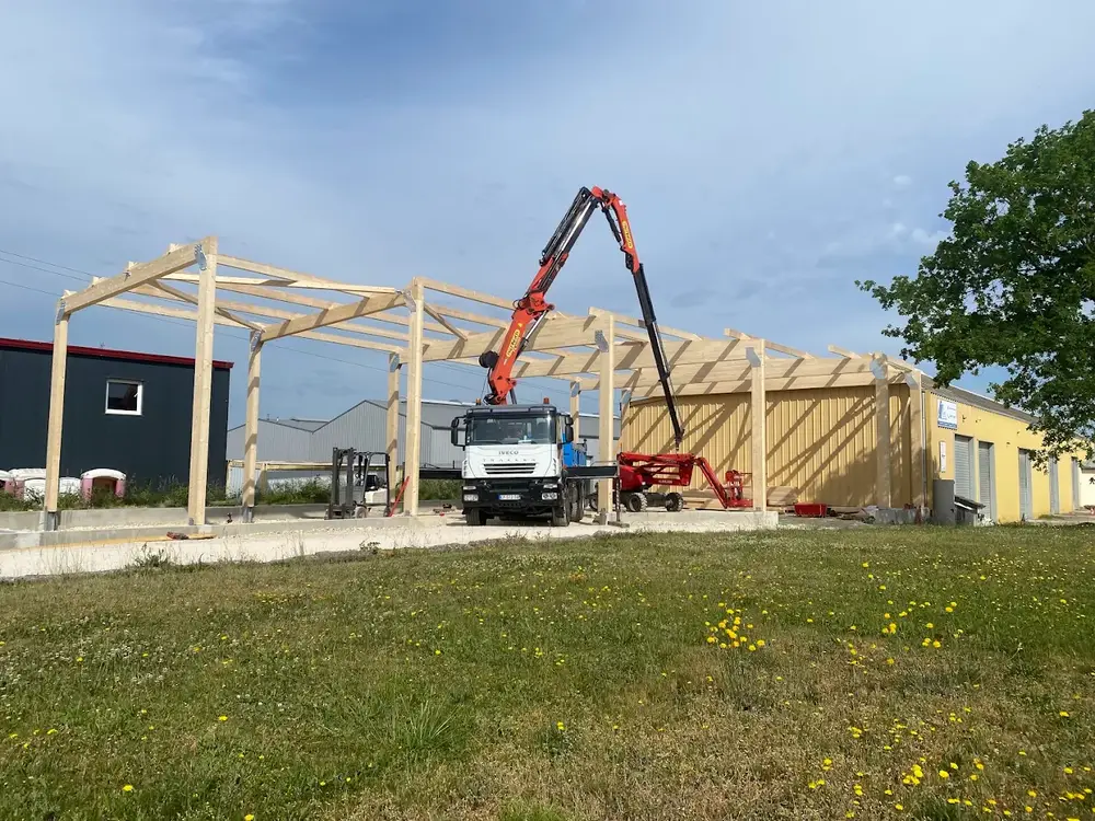 Levage à la grue d'une charpente de grande portée en ossature bois