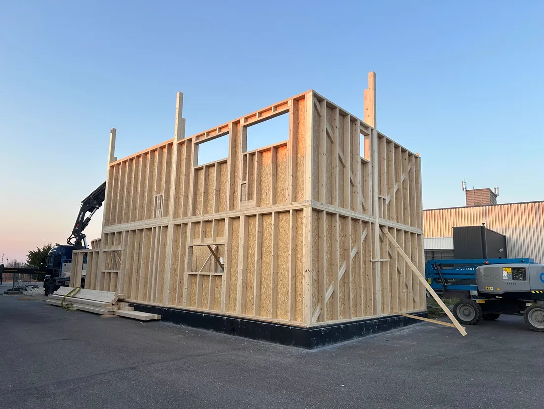 Volume d'ossature bois au crépuscule — chantier LMB Couverture