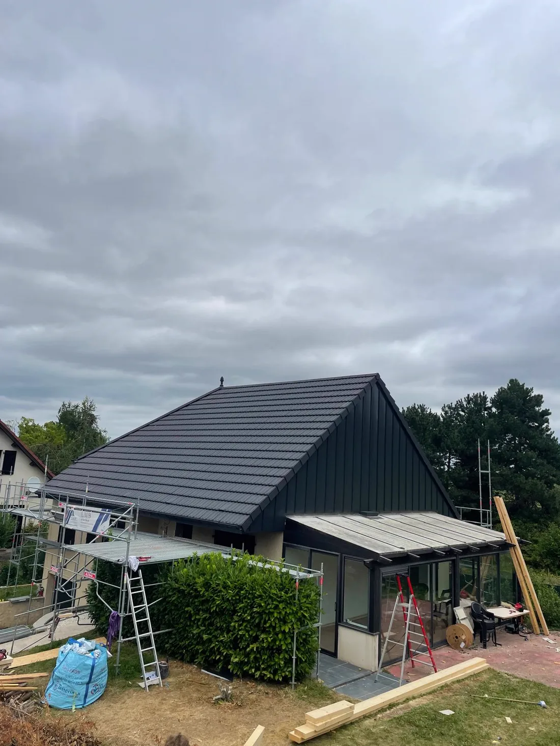 Pavillon surélevé d'un niveau : toiture neuve en tuile plate et pignon habillé en bardage zinc noir