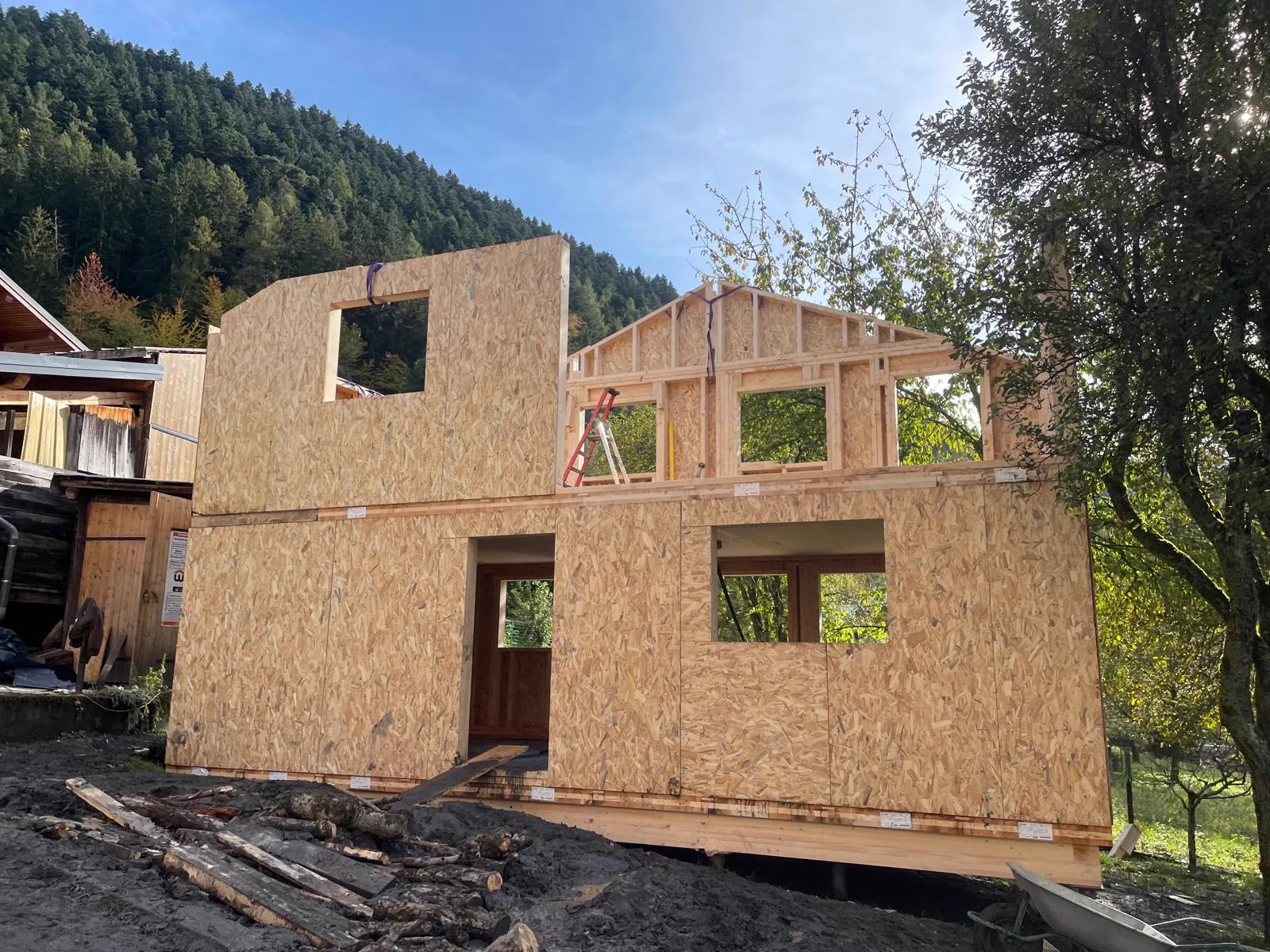 Pignon d'un chalet en ossature bois monté en montagne, devant la forêt
