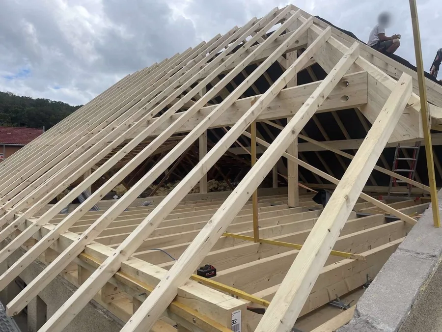 Charpente neuve en sapin montée sur un pavillon : arbalétriers, pannes et chevrons