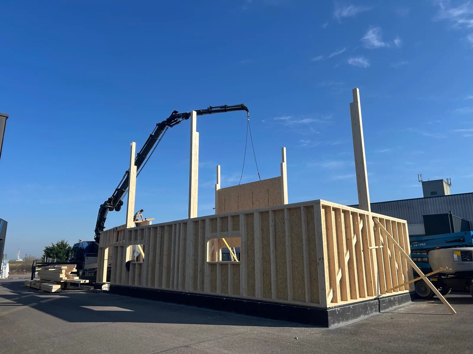 Mur en ossature bois levé au camion-grue sur le chantier d'un bâtiment d'activité