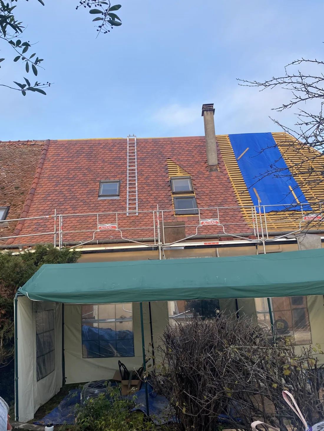 Toiture en cours de rénovation : une moitié encore en ancienne tuile, l'autre déjà en lattage neuf