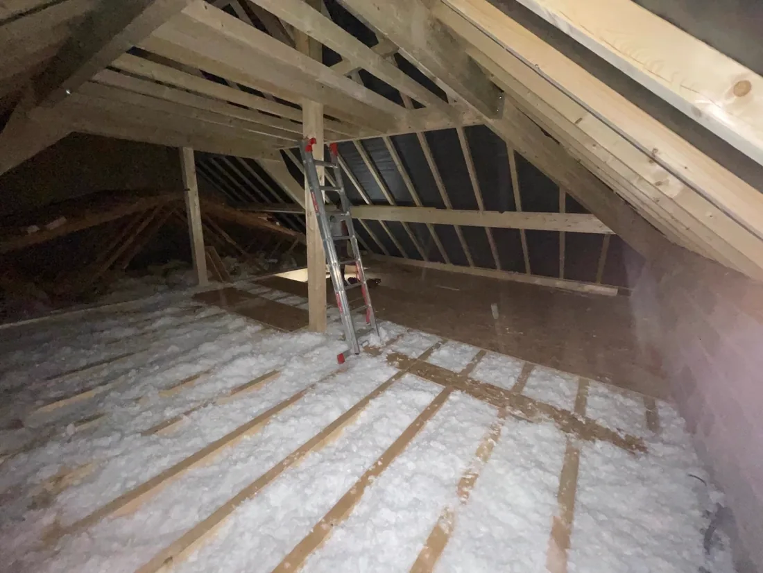 Combles isolés en laine soufflée sous une charpente neuve