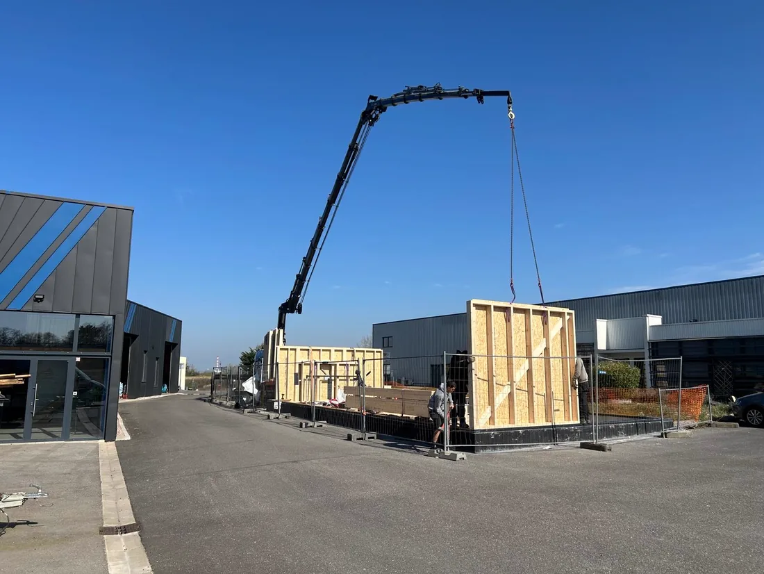 Panneau d'ossature bois descendu à la grue sur le chantier d'un bâtiment d'activité
