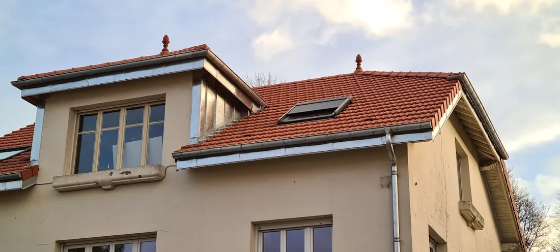 Fenêtre de toit et lucarne habillée en zinc sur une façade