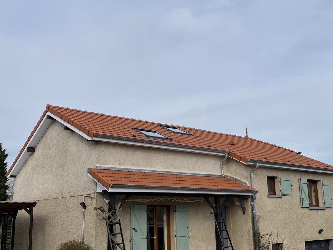 Maison dont la toiture en tuile mécanique neuve porte deux fenêtres de toit