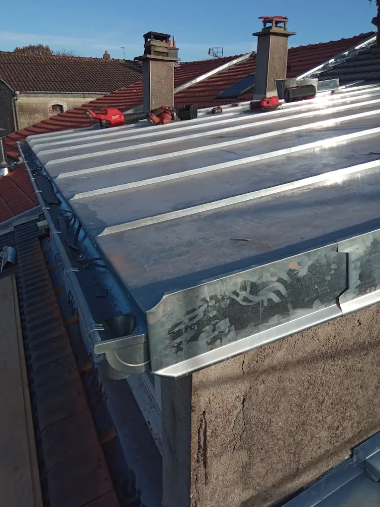 Chéneau en zinc encaissé derrière une corniche, sur un bâtiment ancien