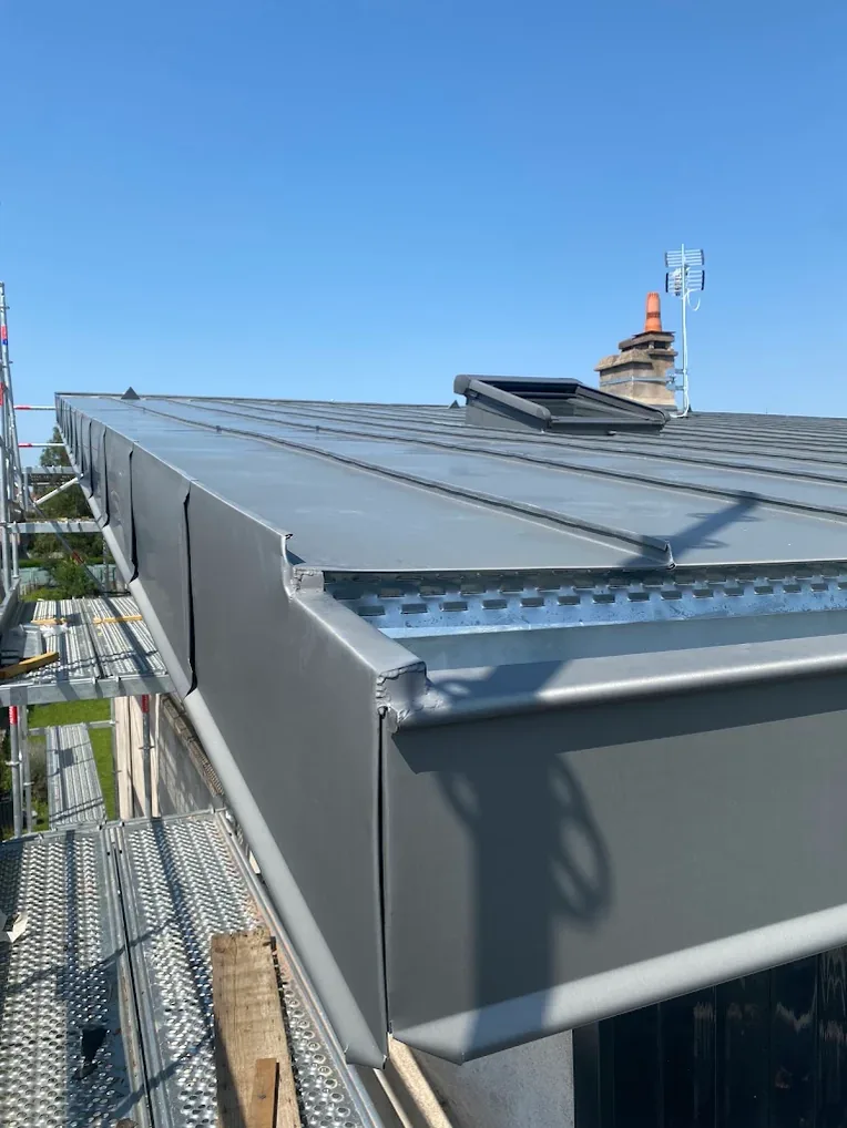Détail d'un ouvrage de zinc façonné sur place, au raccord d'une couverture