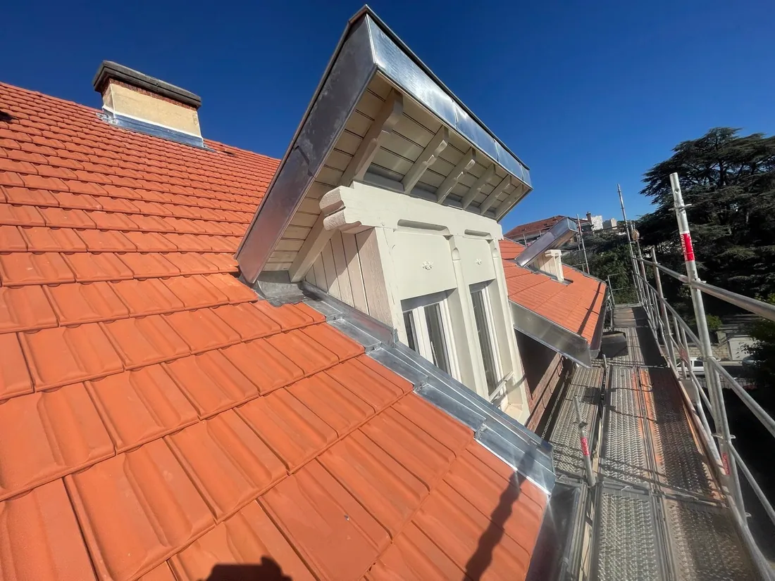 Détail d'une lucarne : joue et fronton habillés de zinc sur une couverture en tuile neuve