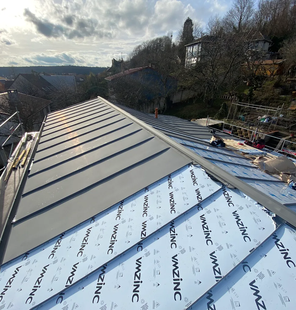 Bacs zinc VMZINC en cours de pose sur une toiture, film de protection encore en place