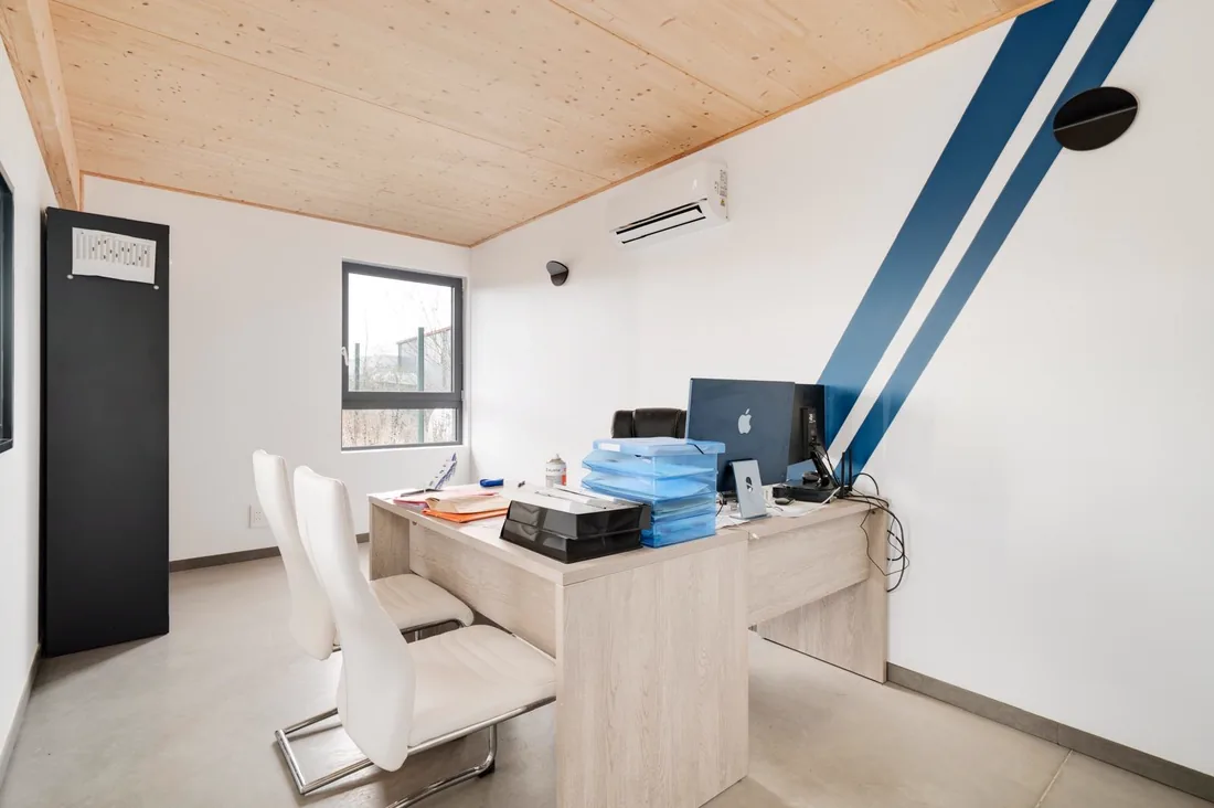 Le bureau du siège de LMB Couverture, avec les obliques bleues du logo peintes sur le mur