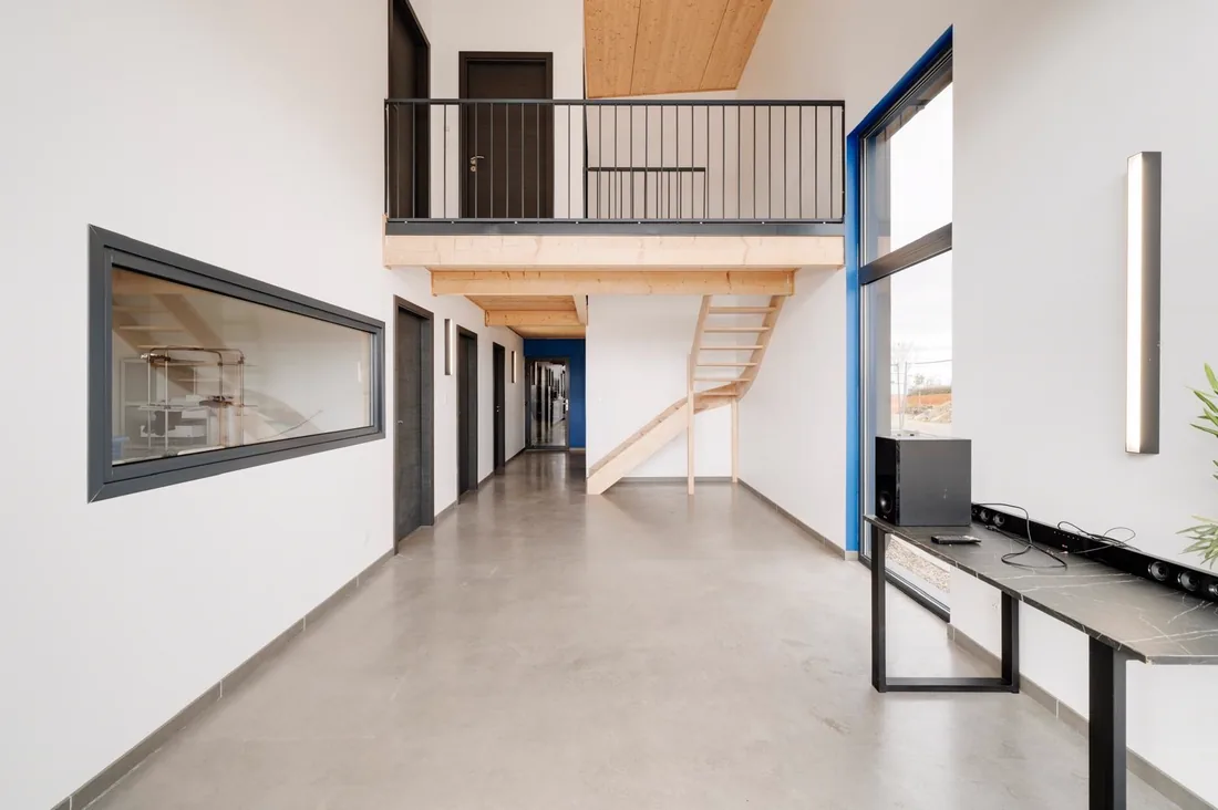 Le hall du siège de LMB Couverture, mezzanine et escalier en bois massif